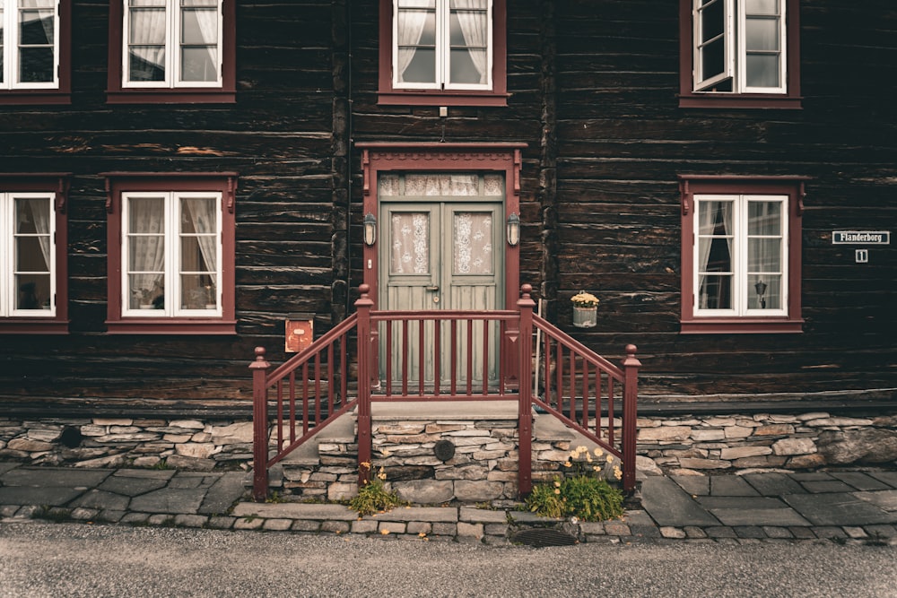 a wooden house with red trim and windows