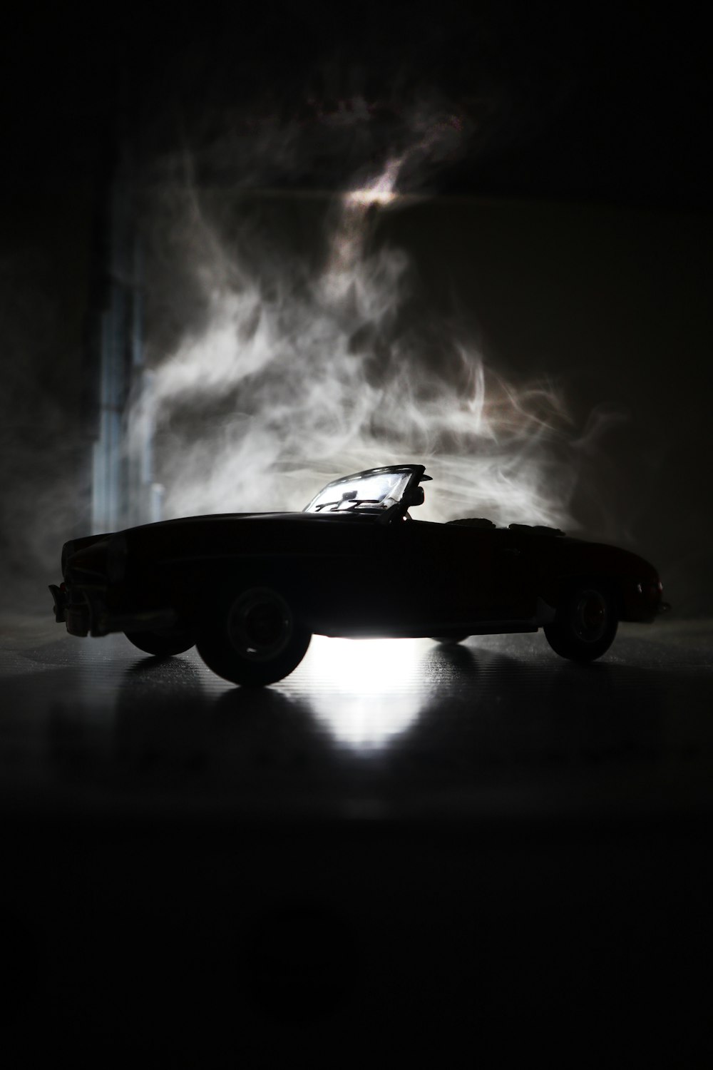 a toy car in the dark with smoke coming out of it