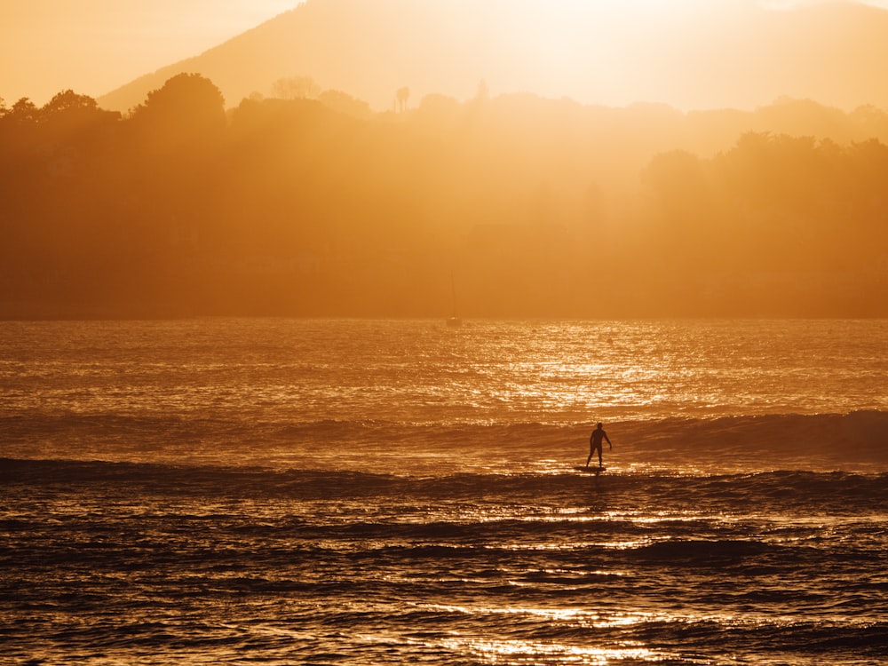 a person riding a surf board on a body of water