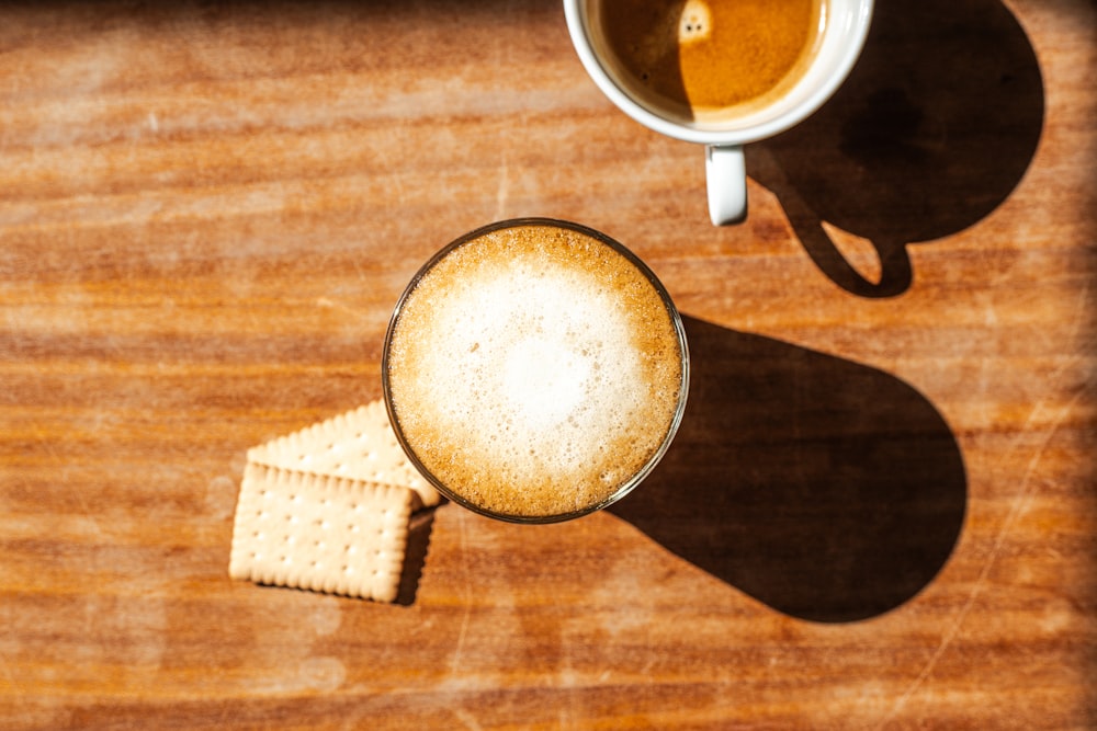 eine Tasse Kaffee und Cracker auf einem Holztisch