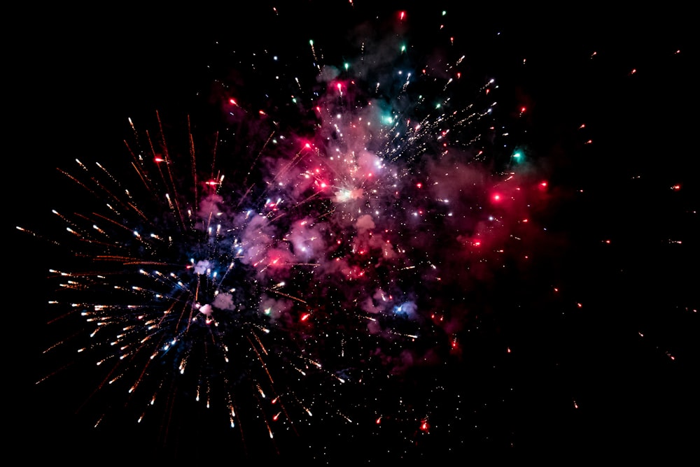 a colorful fireworks is lit up in the night sky