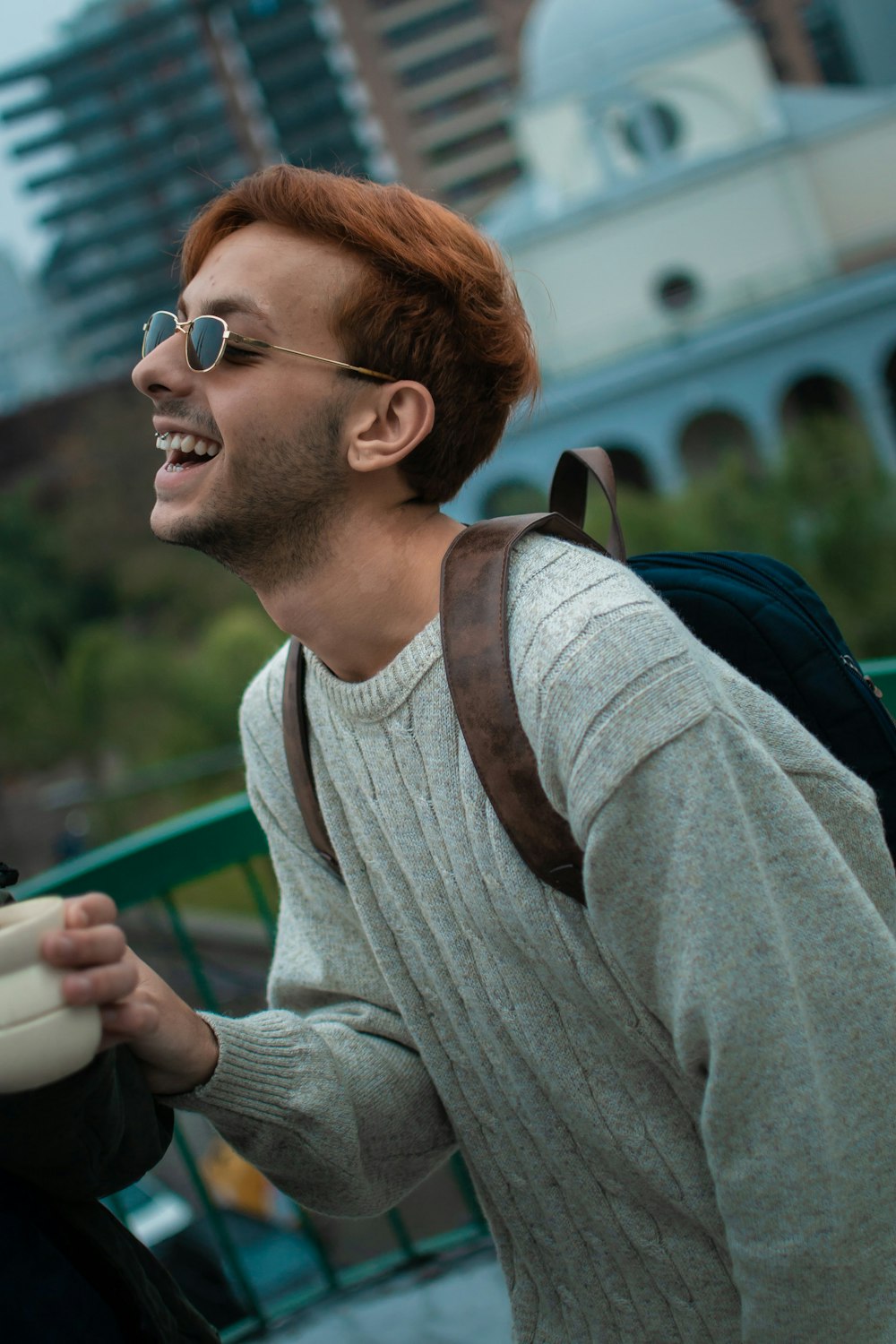 a man with red hair wearing sunglasses and a backpack