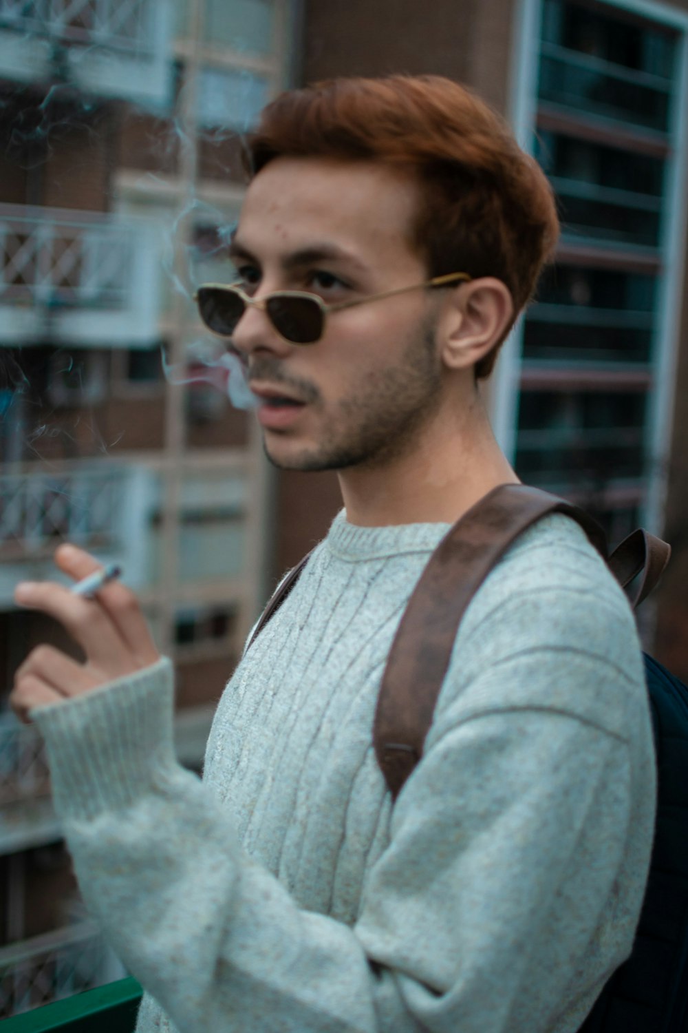 a man with a backpack smoking a cigarette