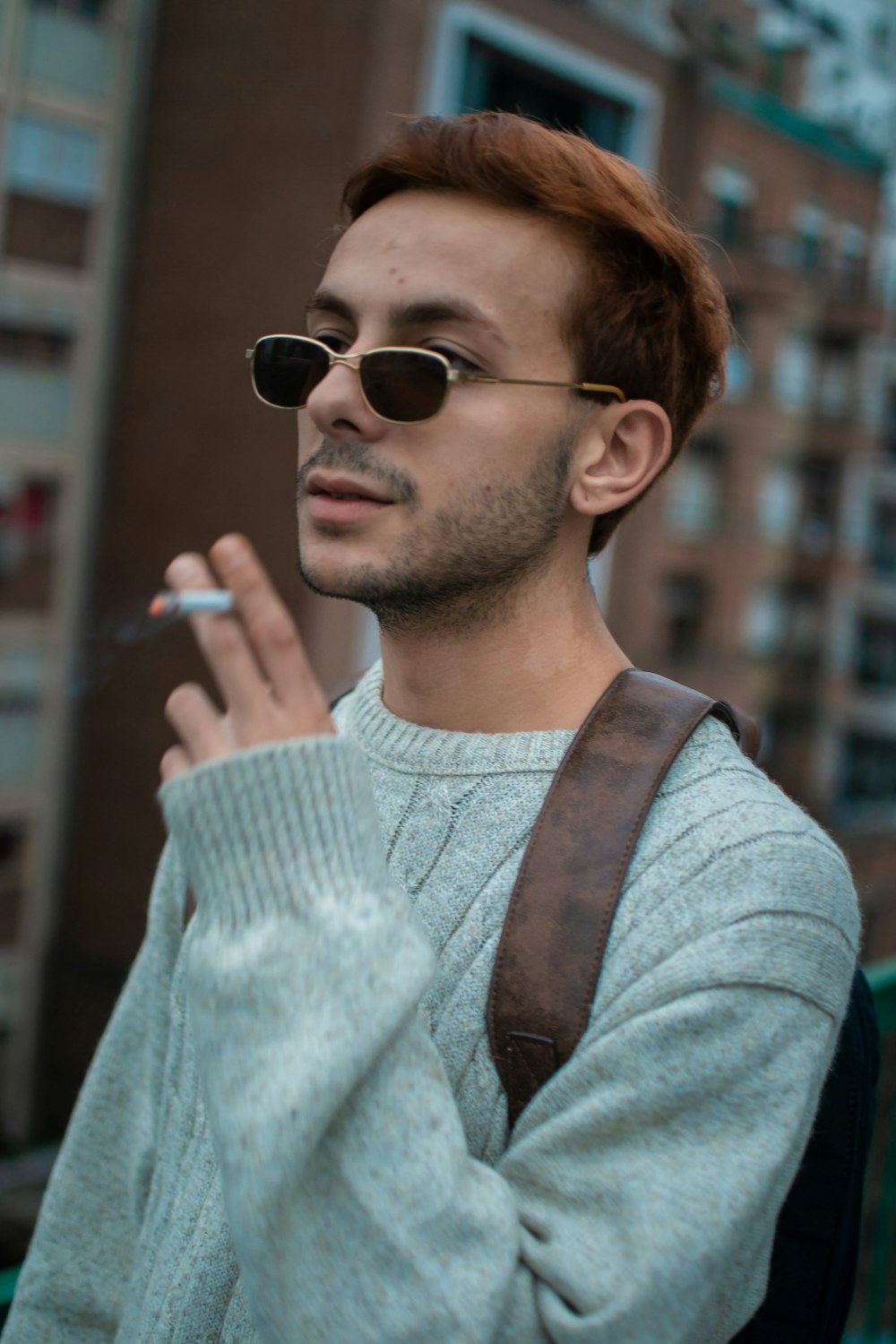 a man smoking a cigarette while wearing sunglasses