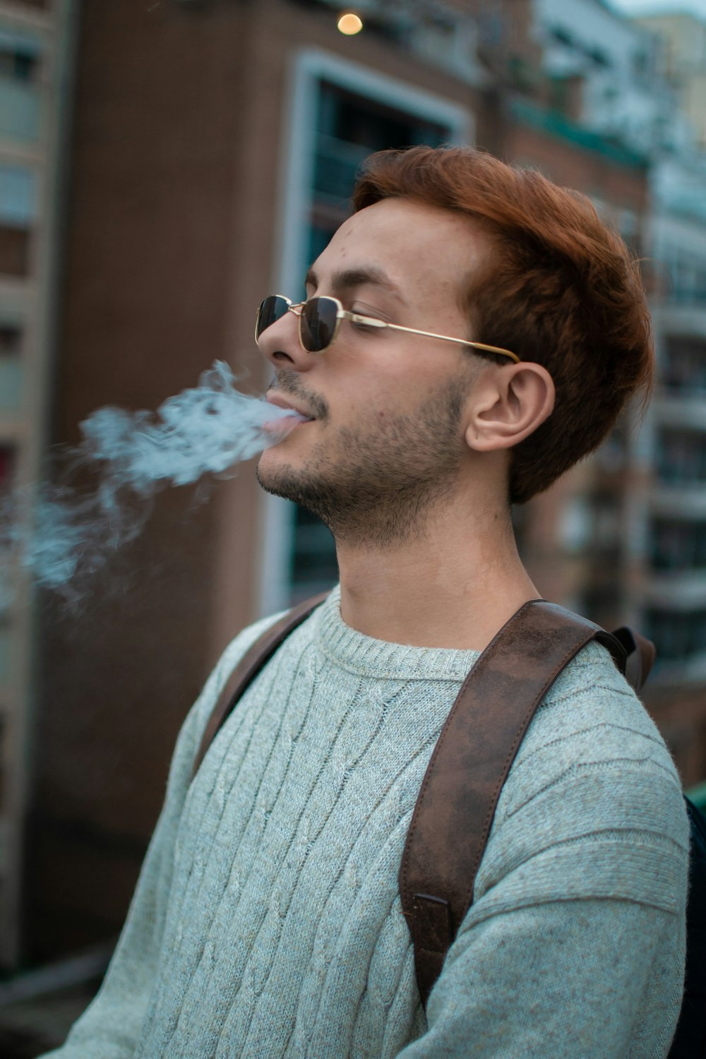 a man smoking a cigarette on a city street