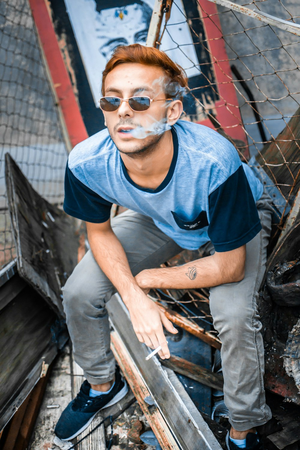 a man sitting on top of a boat with a cigarette in his mouth