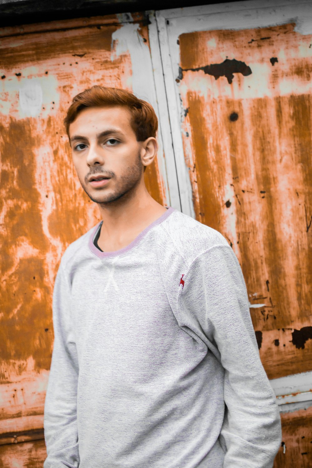 a man standing in front of a rusty door