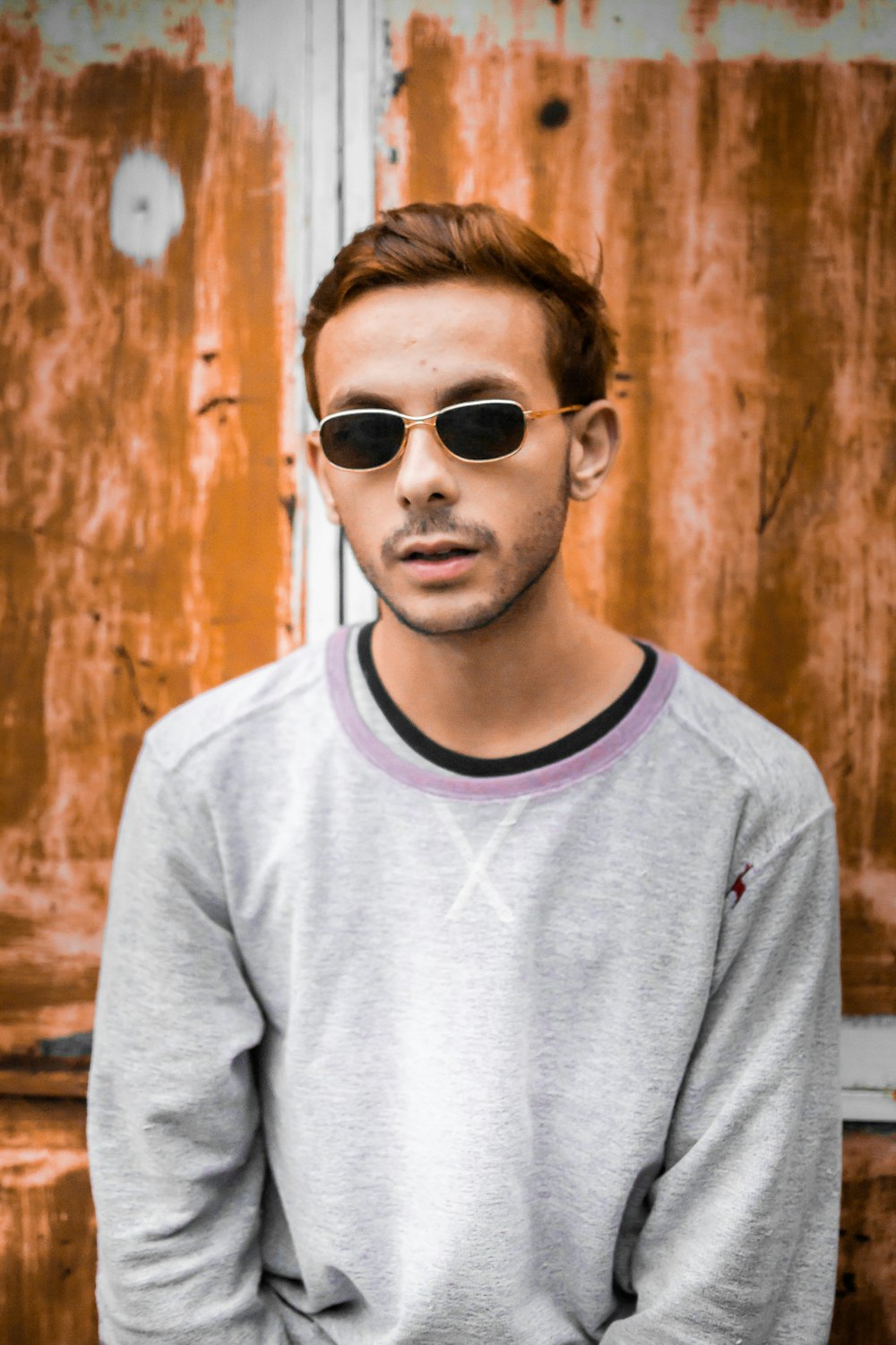 a man wearing sunglasses standing in front of a door