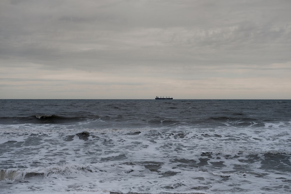 a boat in the ocean on a cloudy day