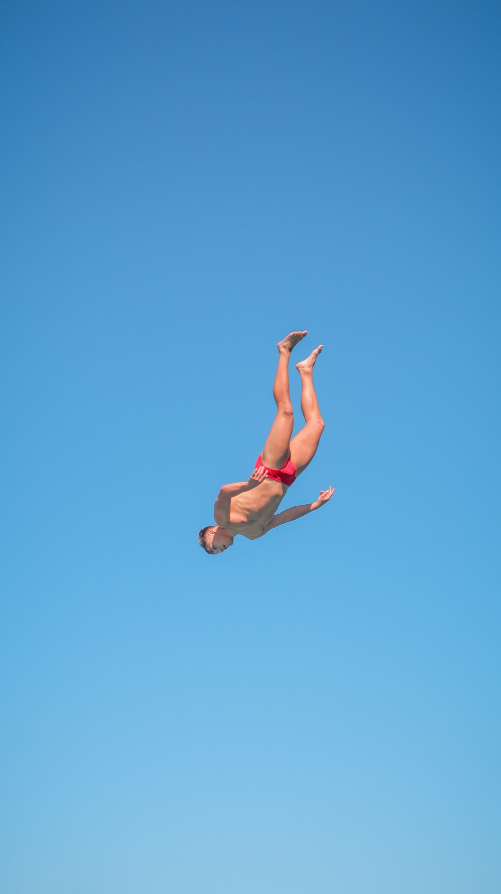 a woman in a red bikini is in the air