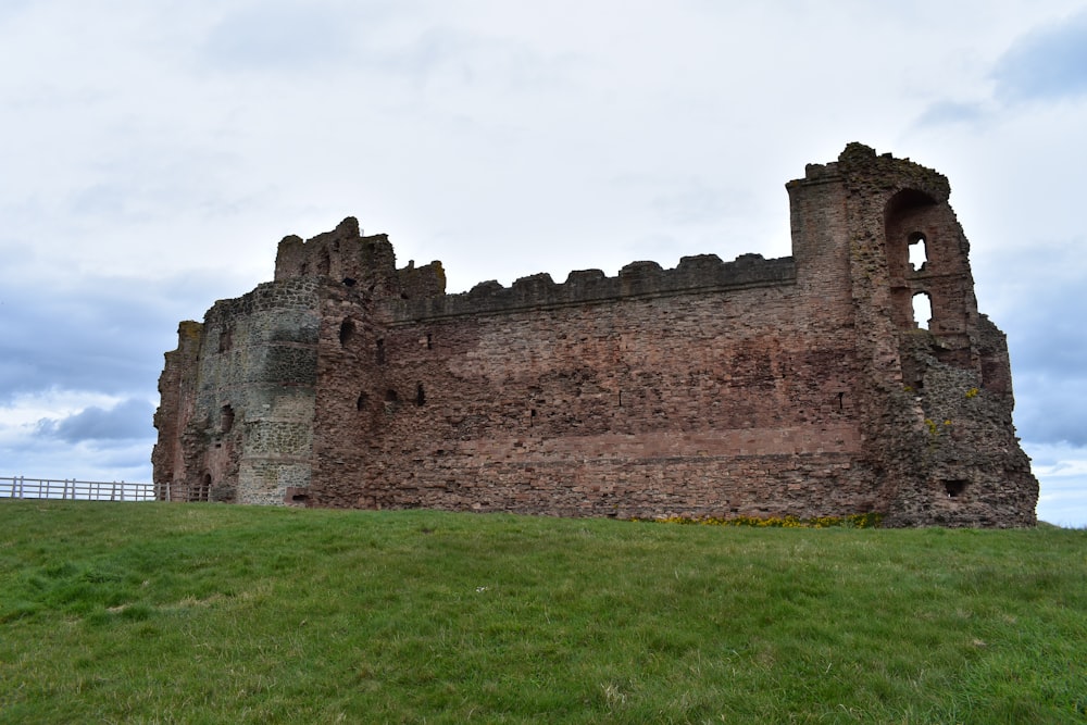 a large stone building sitting on top of a lush green field