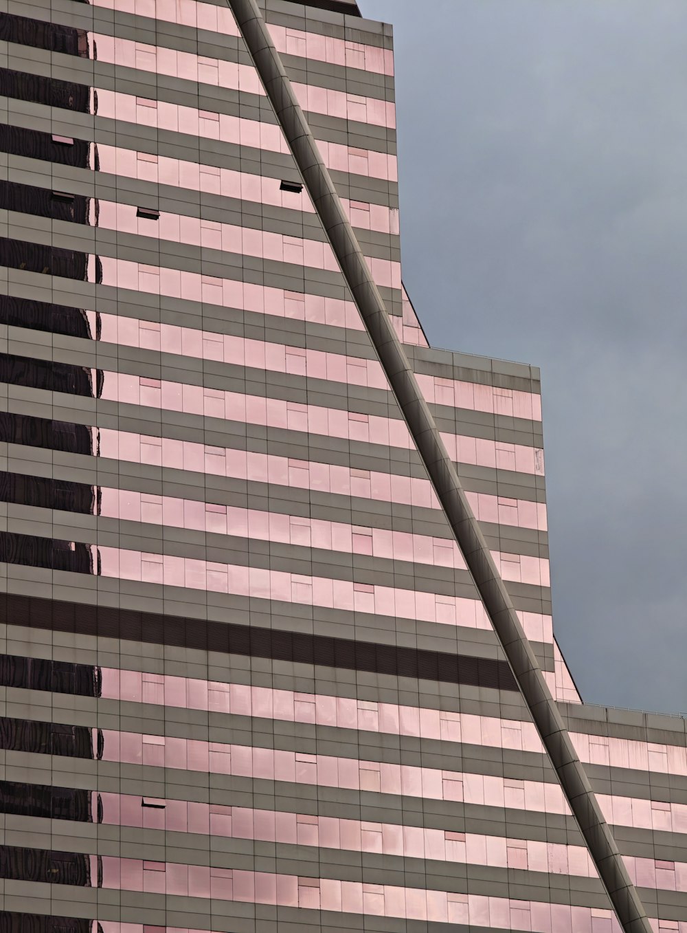 ピンク色の背の高い建物で、その前に信号機があります