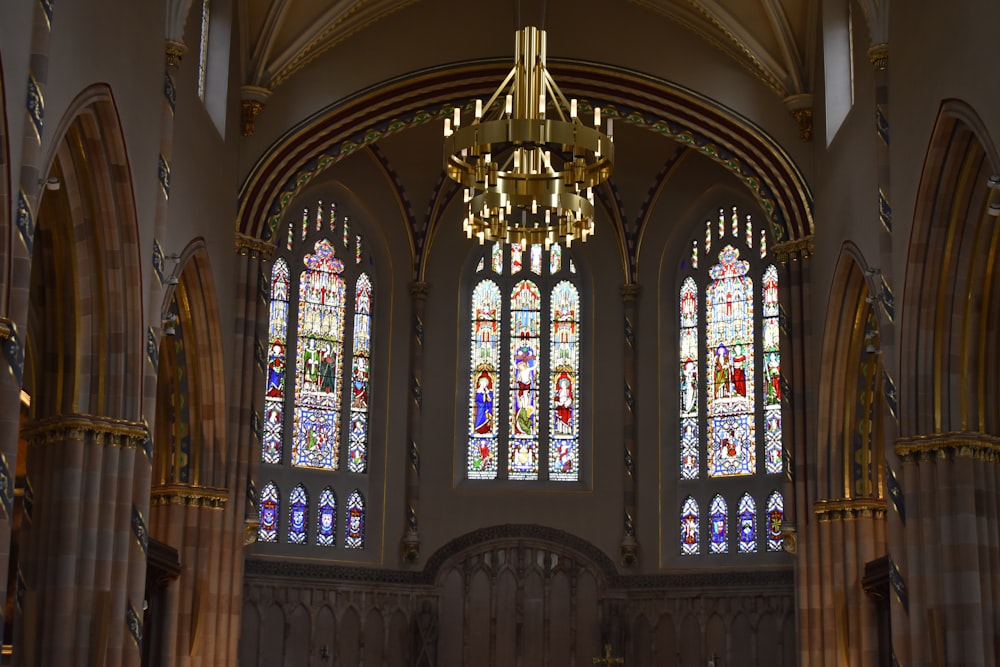 a church with a chandelier and stained glass windows