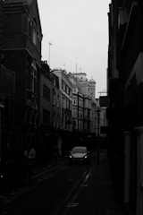 a car driving down a street next to tall buildings