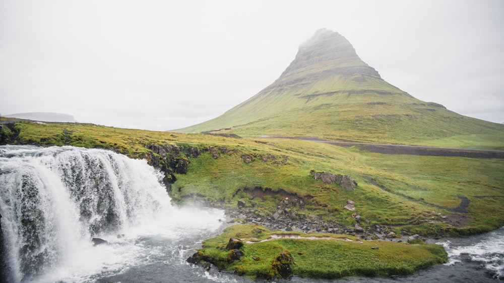 a waterfall with a mountain in the background