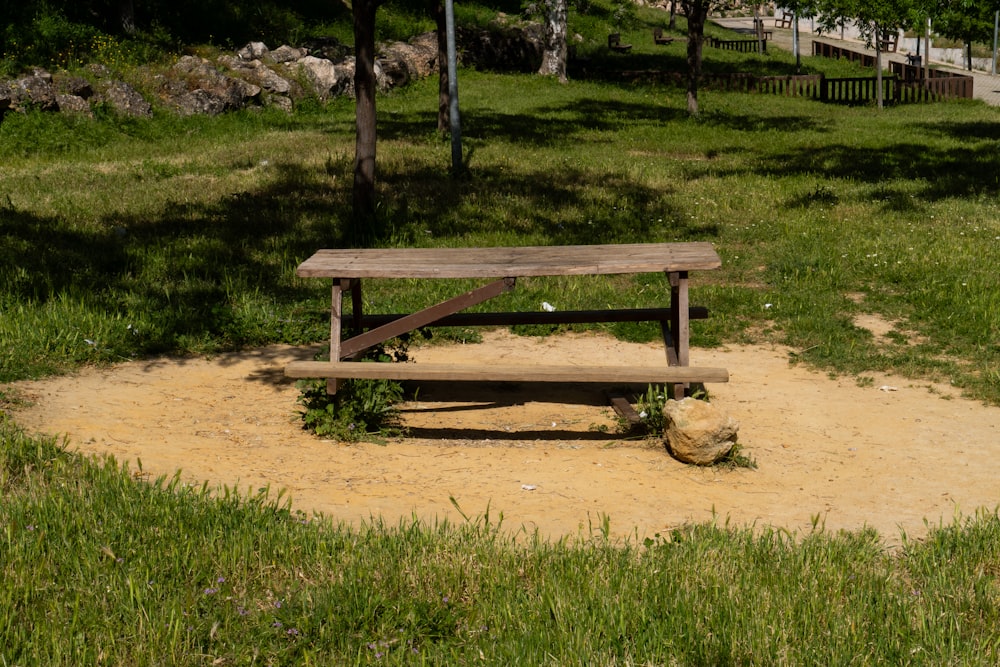 a wooden bench sitting in the middle of a field