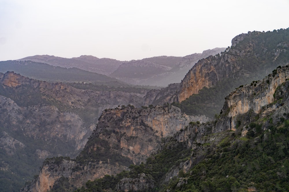 a view of a mountain range with trees and mountains in the background