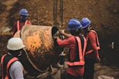 a group of men standing around a large metal barrel