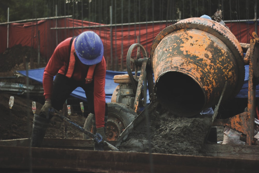 a man in a hard hat working on a pipe