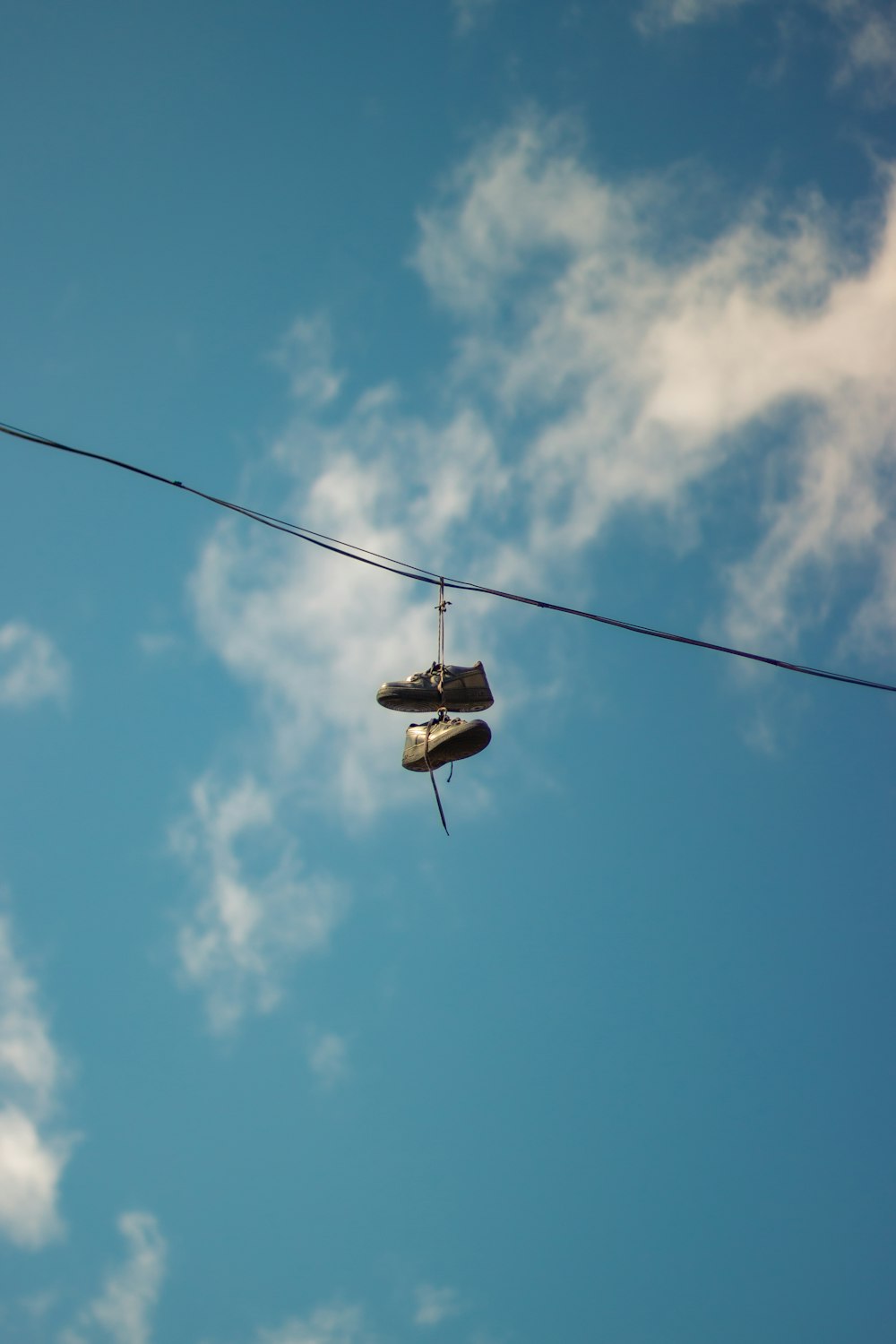 a pair of shoes hanging from a power line