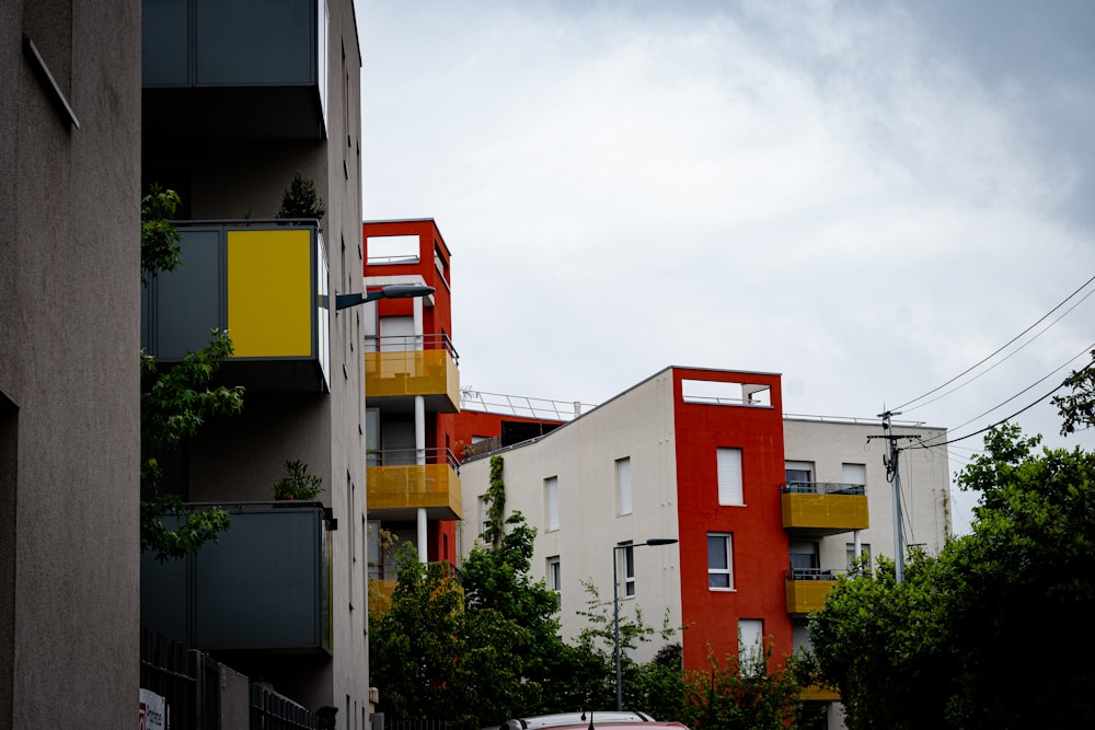 a red car is parked in front of a multi - colored building