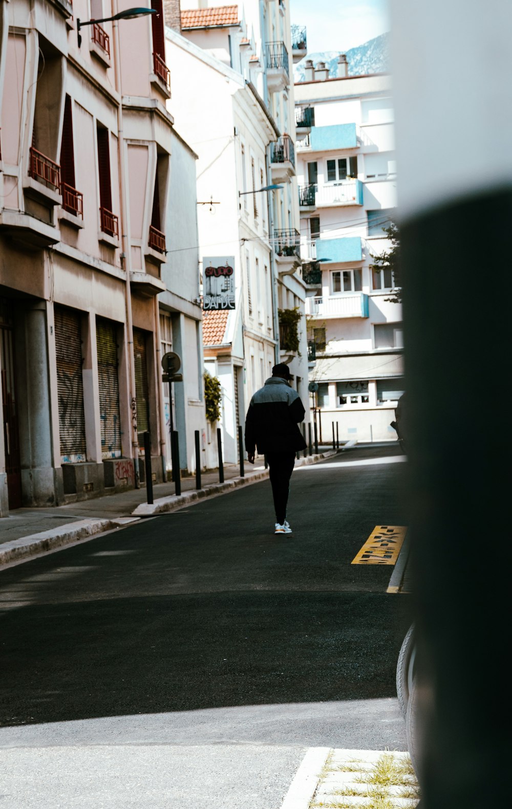 a person walking down a street with buildings in the background