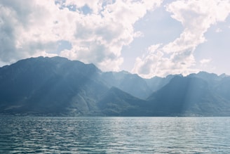 a large body of water with mountains in the background