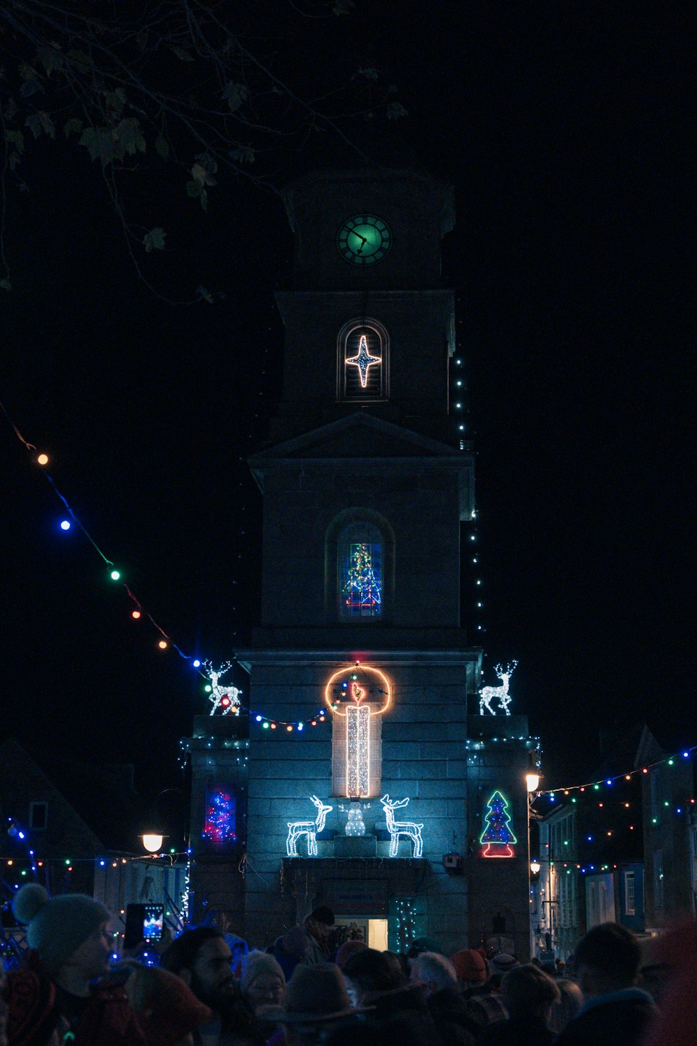 a crowd of people standing in front of a church at night