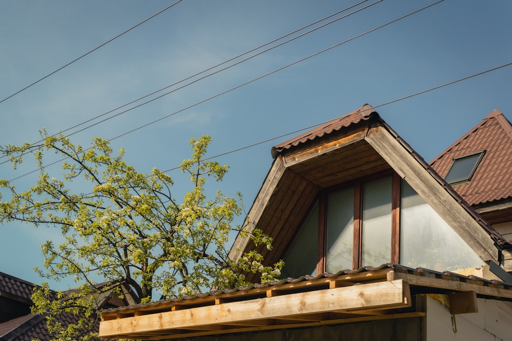 el techo de una casa con un árbol frente a él