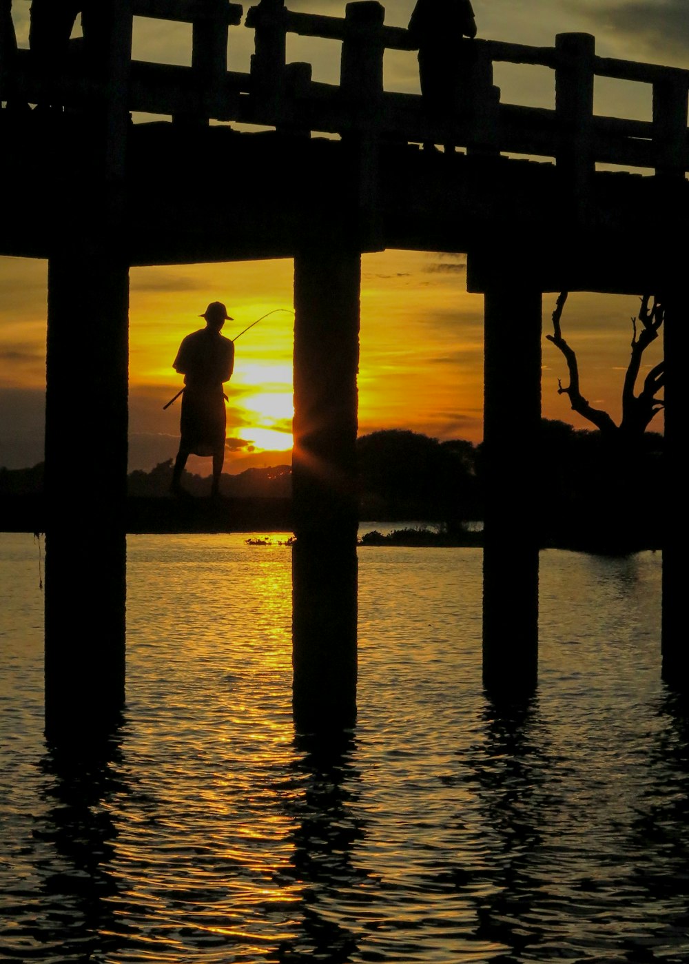 a man standing on top of a pier next to a body of water