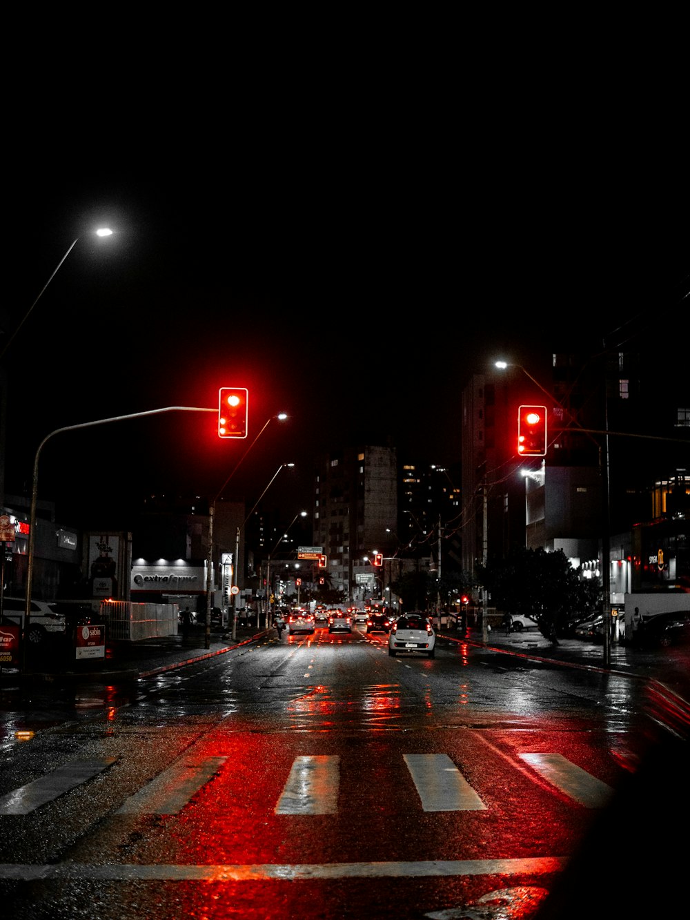 a city street at night with a red traffic light