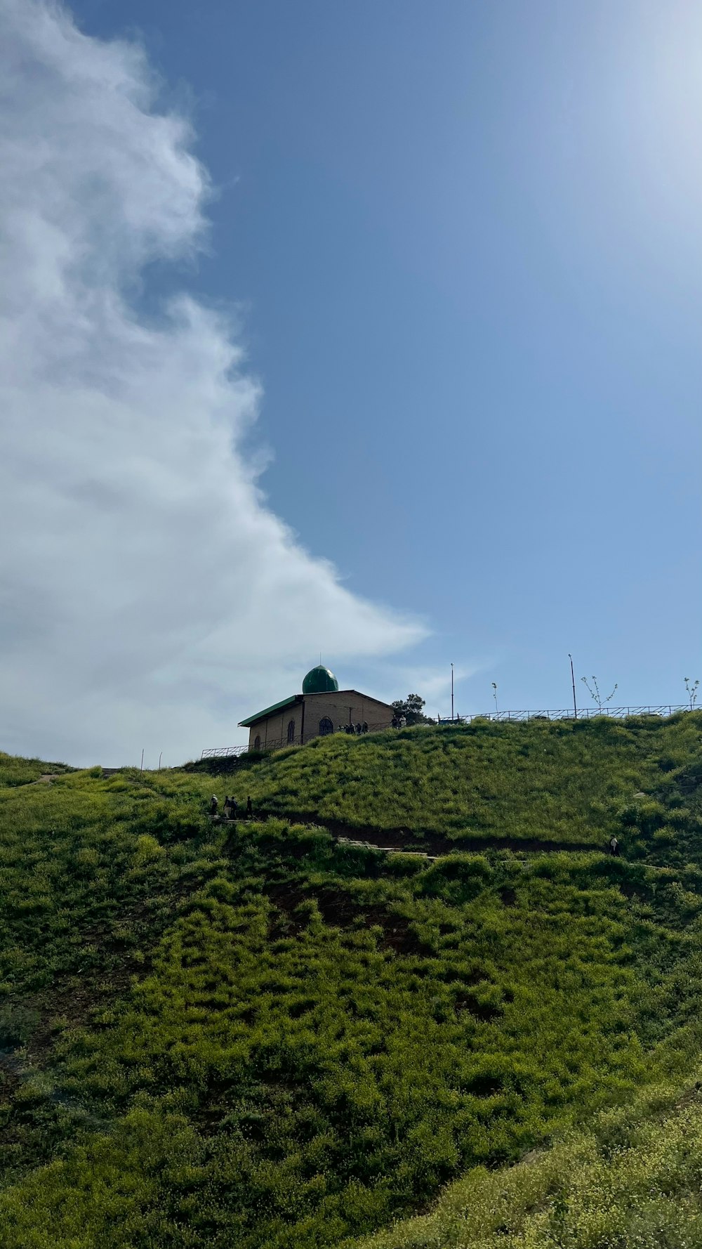 una colina cubierta de hierba con una casa en la cima