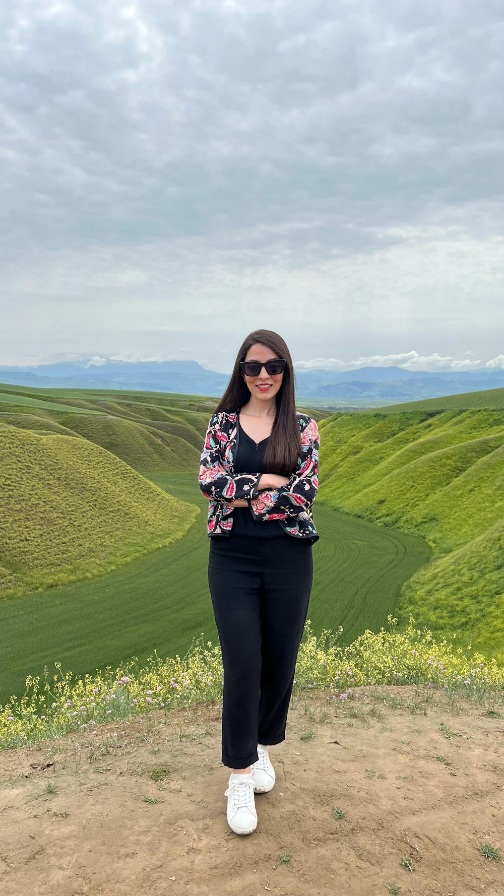 a woman standing on top of a dirt field