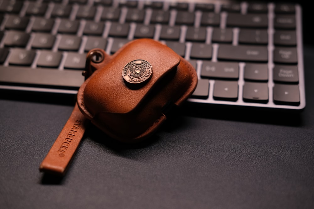 a leather keychain sitting on top of a keyboard