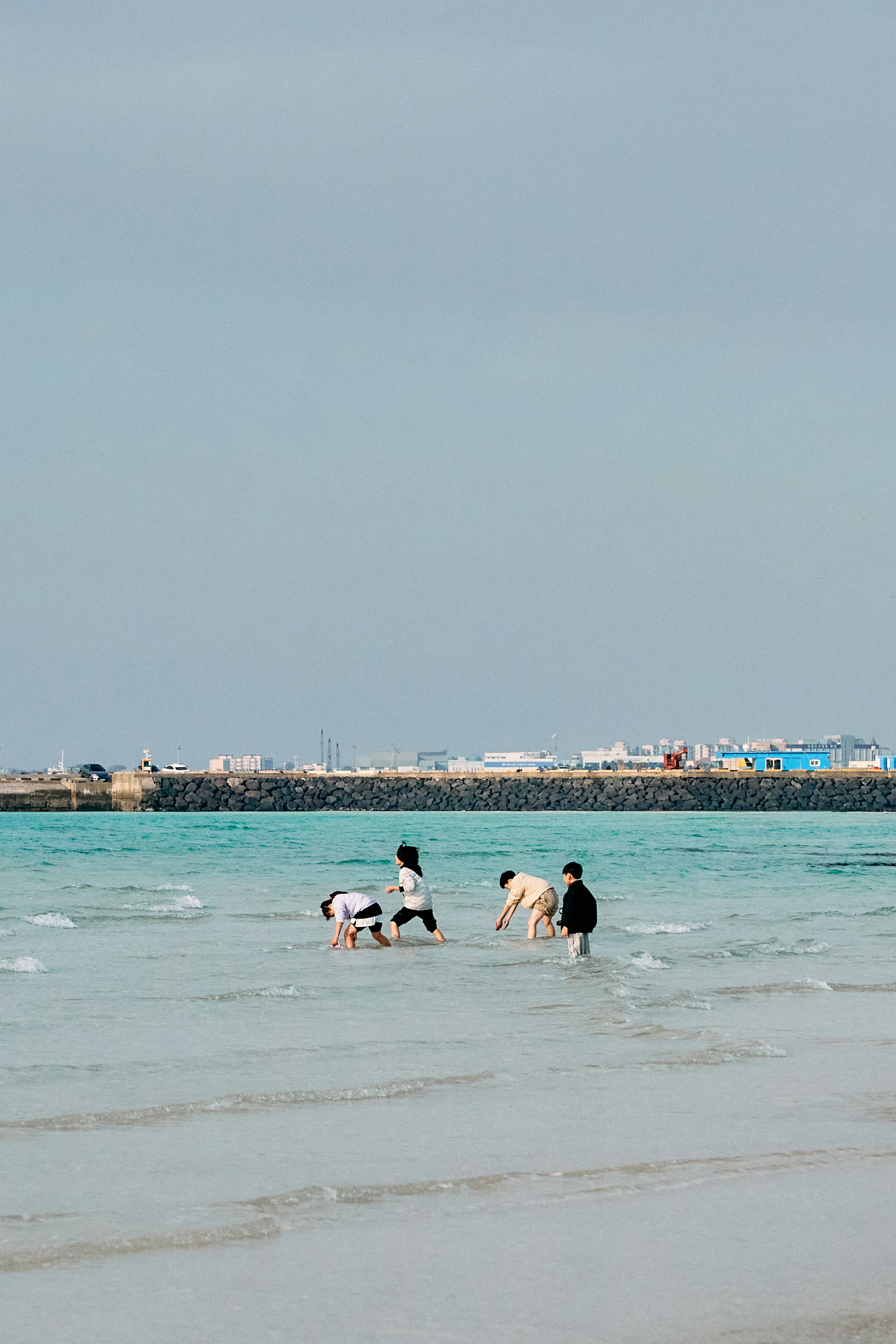 a group of people playing in the water at the beach