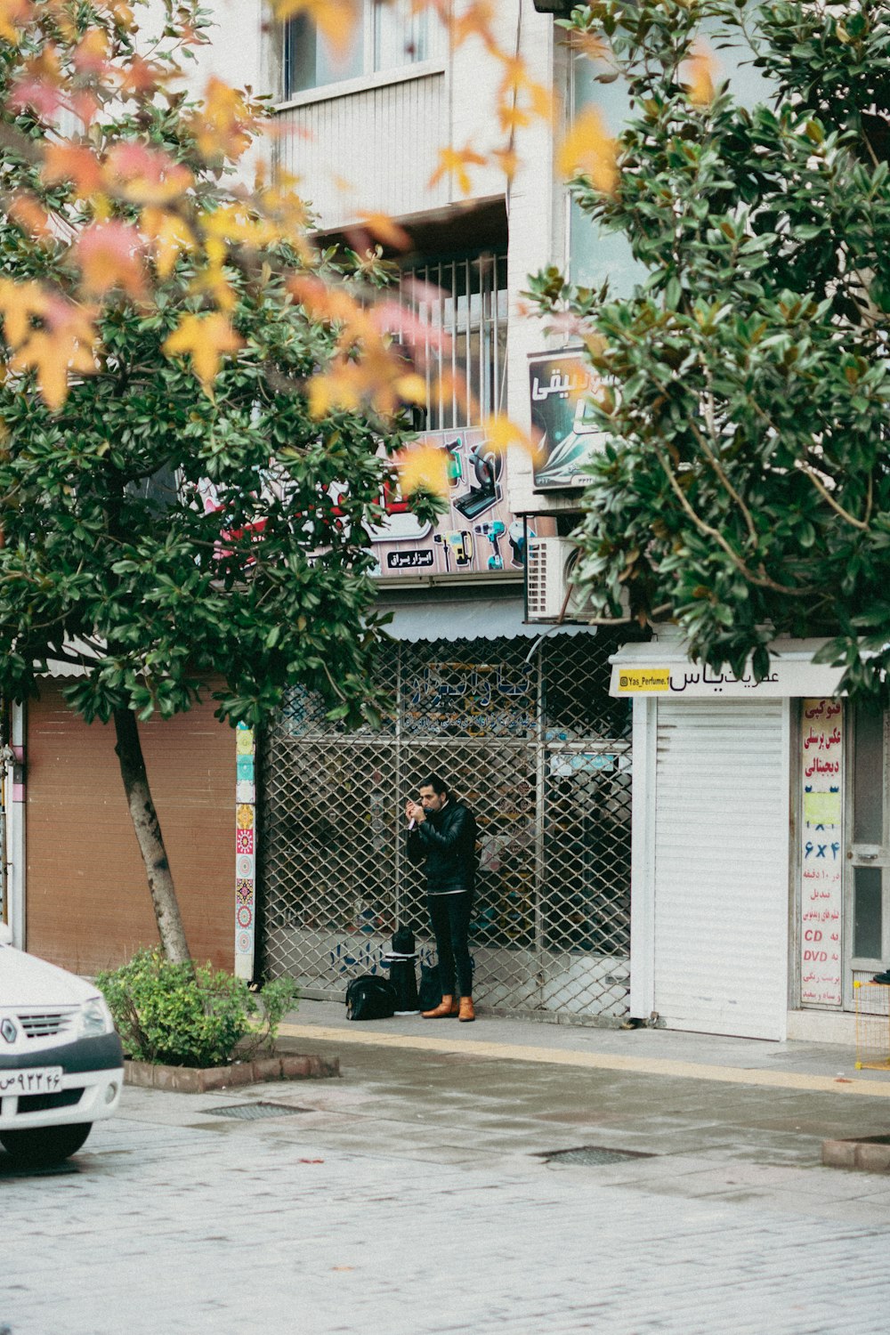 a man standing in front of a building with a suitcase