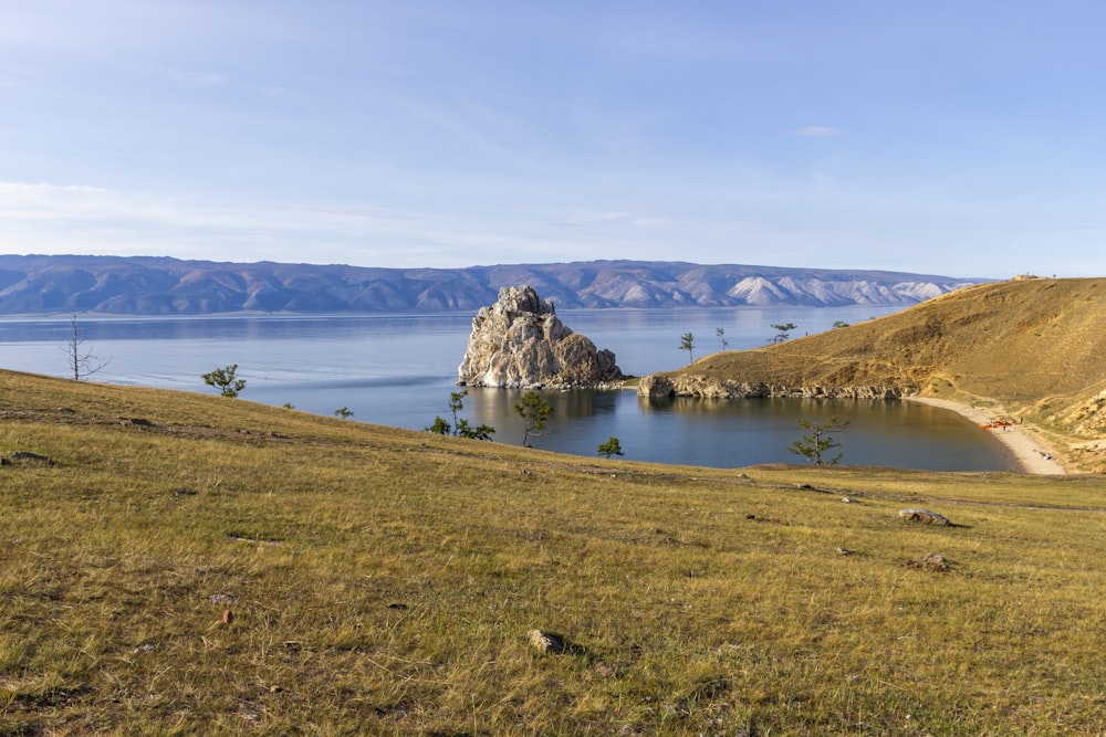 a large body of water sitting on top of a lush green hillside