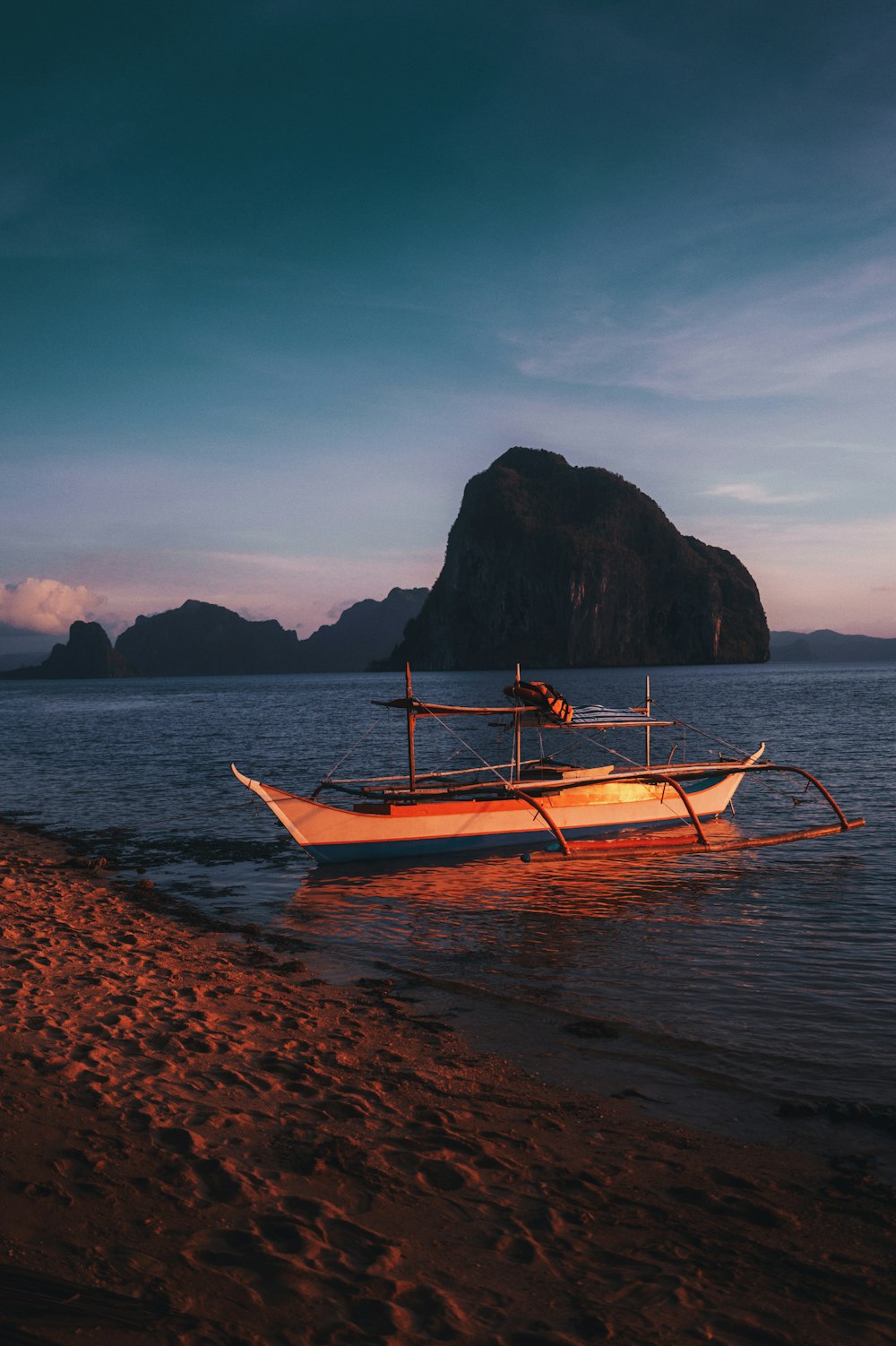 a boat sitting on top of a sandy beach