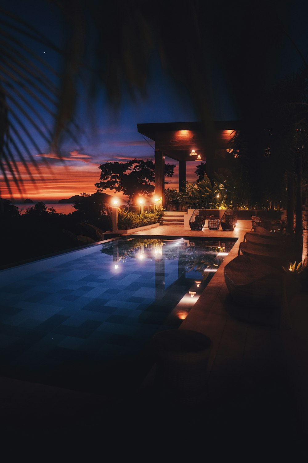 a swimming pool at night with lights on