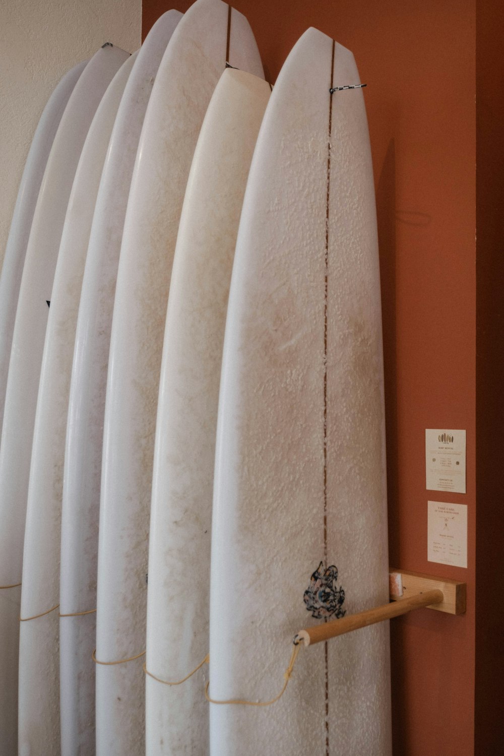 a row of white surfboards mounted to a wall