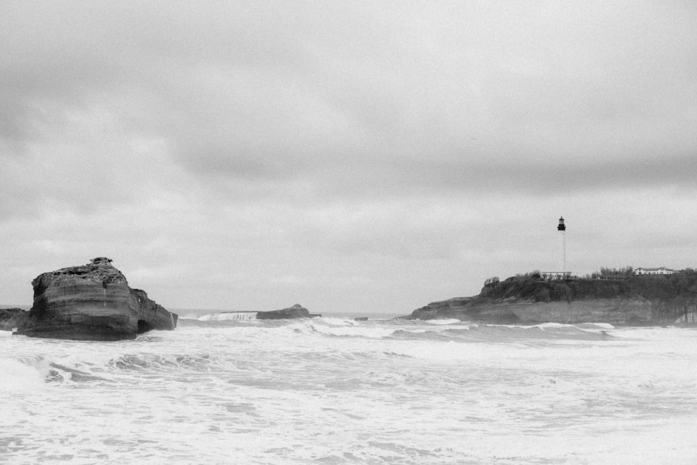 a black and white photo of waves crashing on a beach