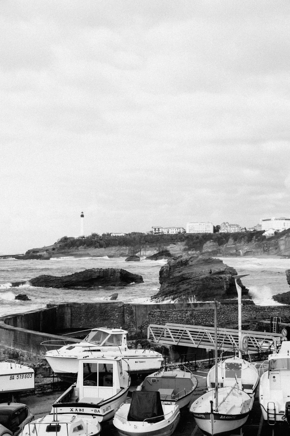 a black and white photo of boats docked at a pier