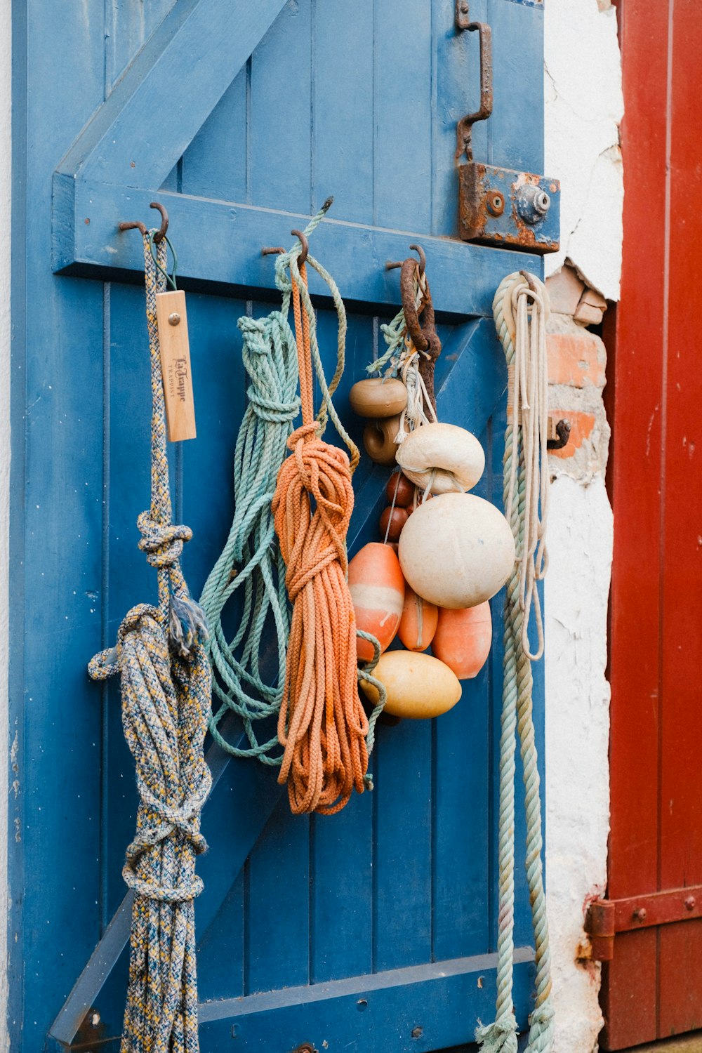 a blue door with ropes and buoys attached to it