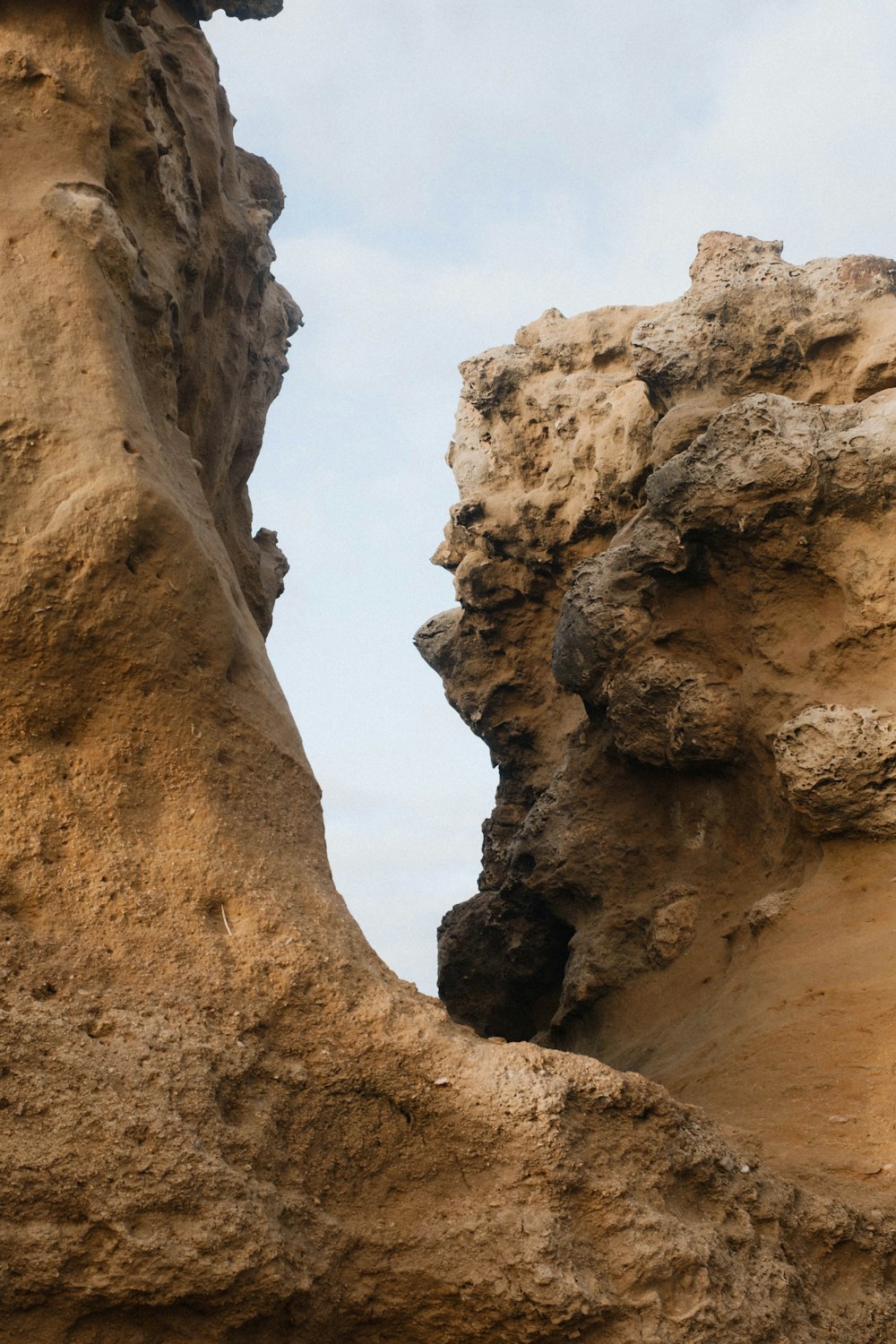 a giraffe standing in between two large rocks