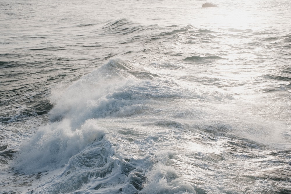 a person riding a surfboard on top of a wave