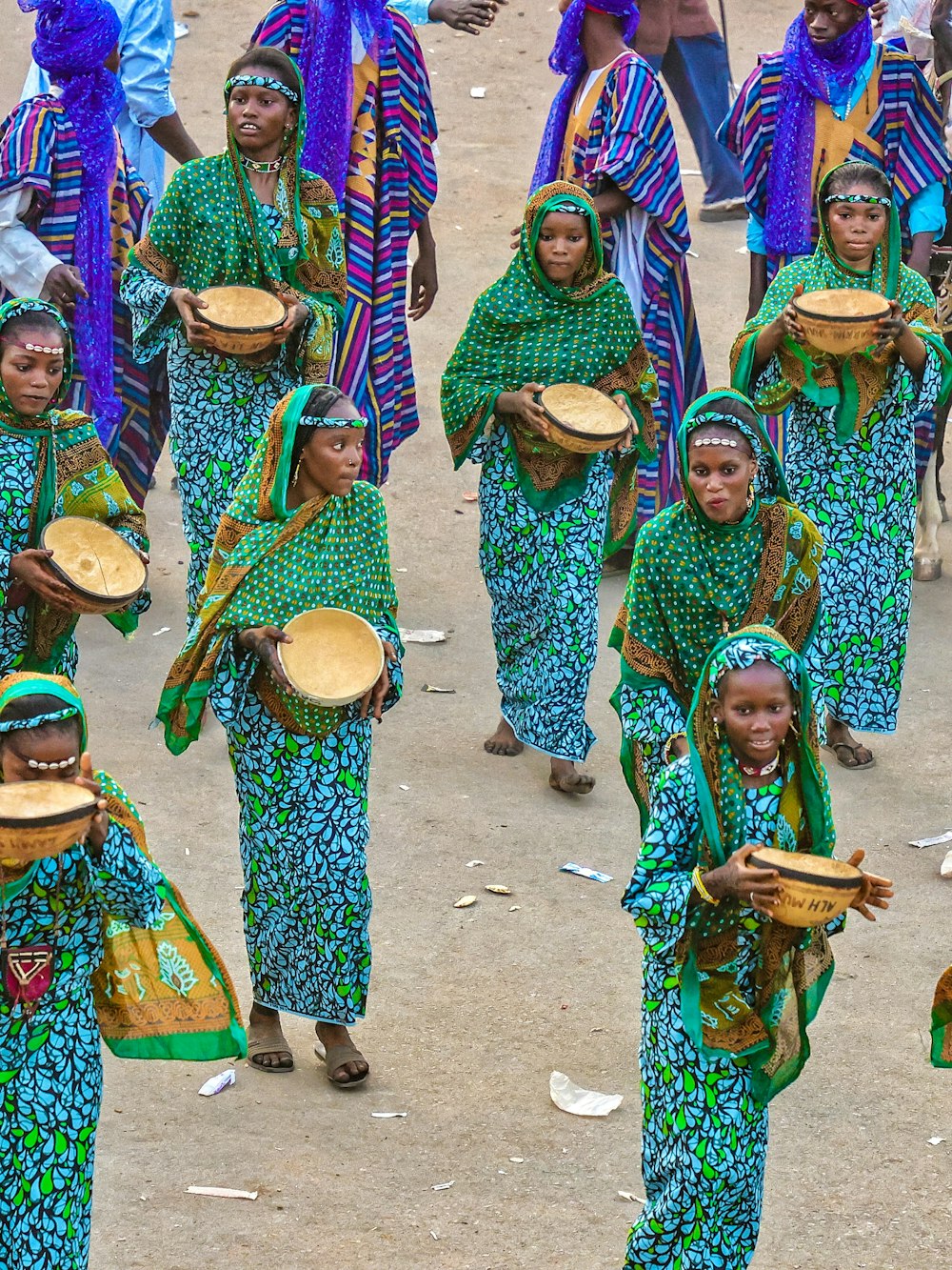 a group of women walking down a dirt road