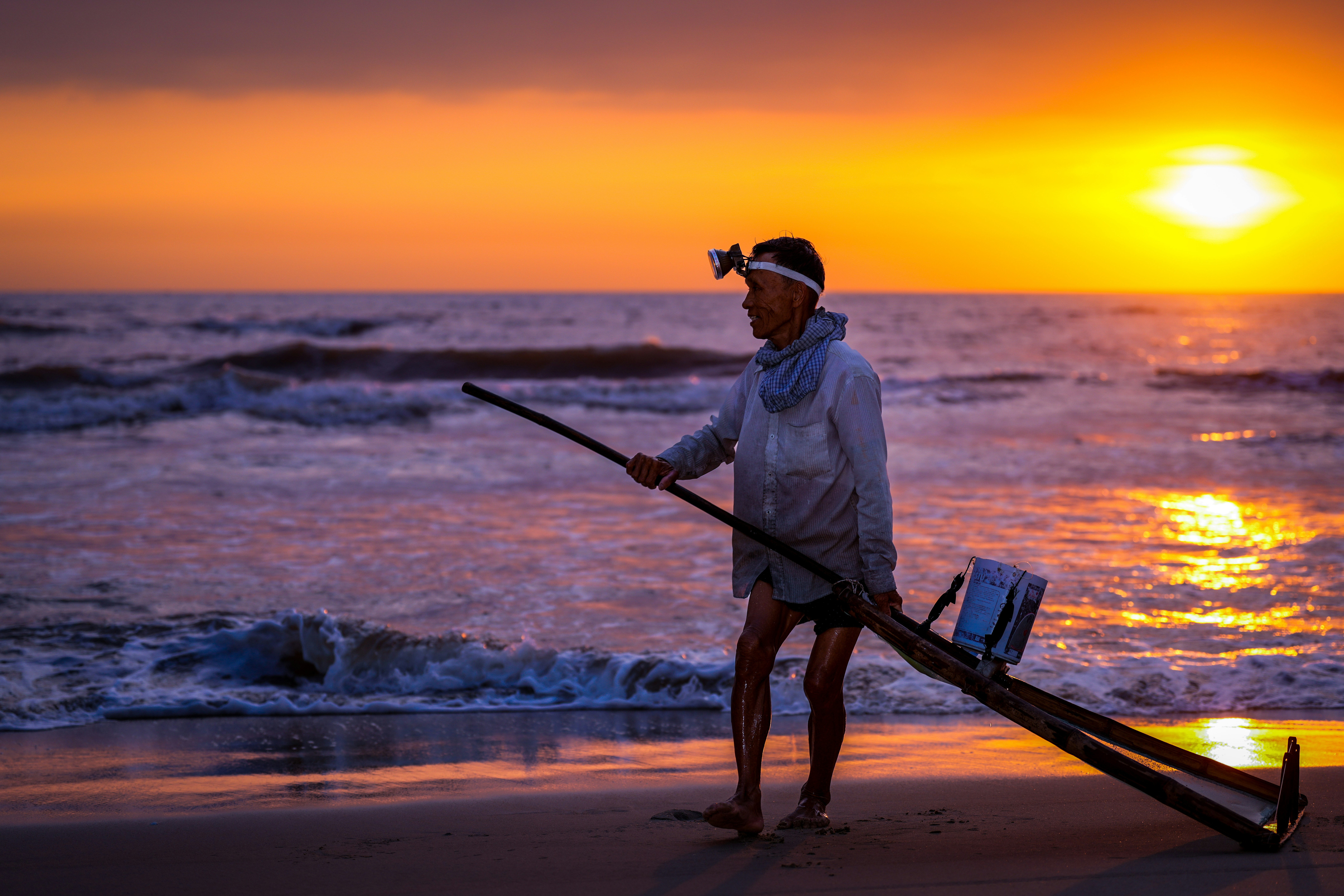Un homme debout au sommet d’une plage à côté de l’océan