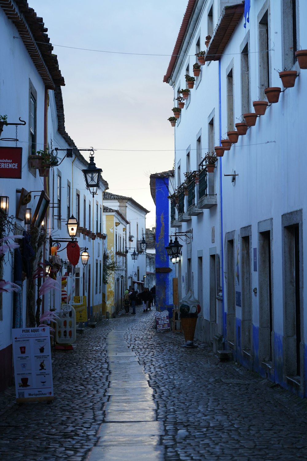 a cobblestone street lined with white buildings