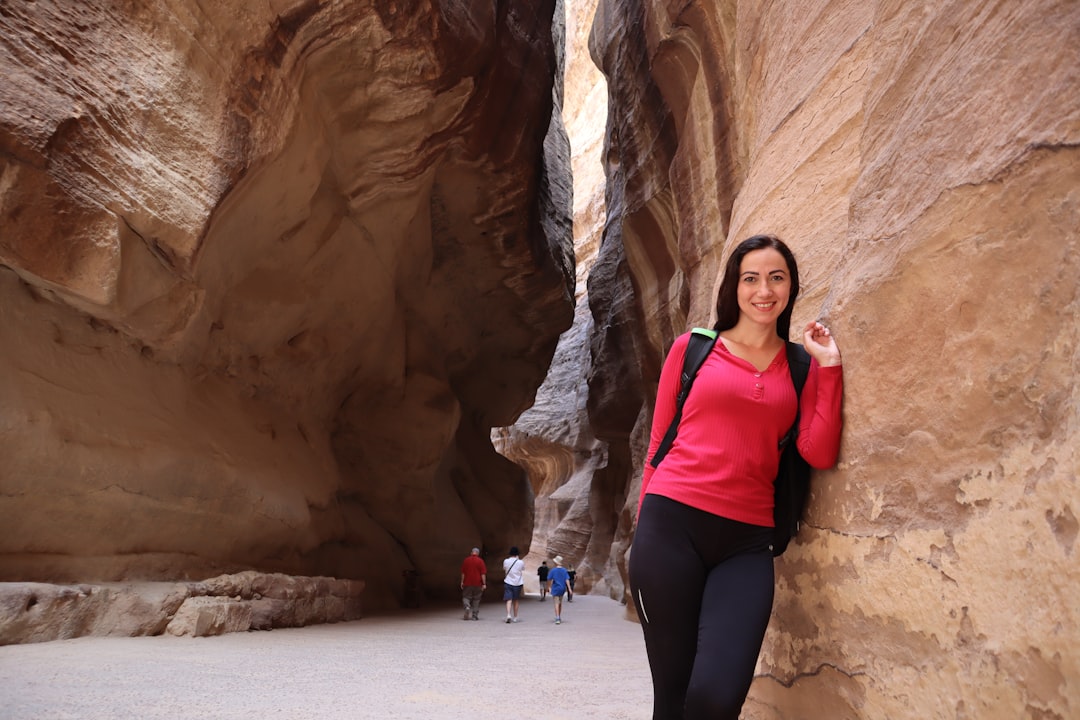 a woman standing in a narrow slot in a canyon,