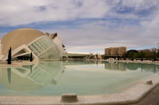 a large building sitting next to a pool of water